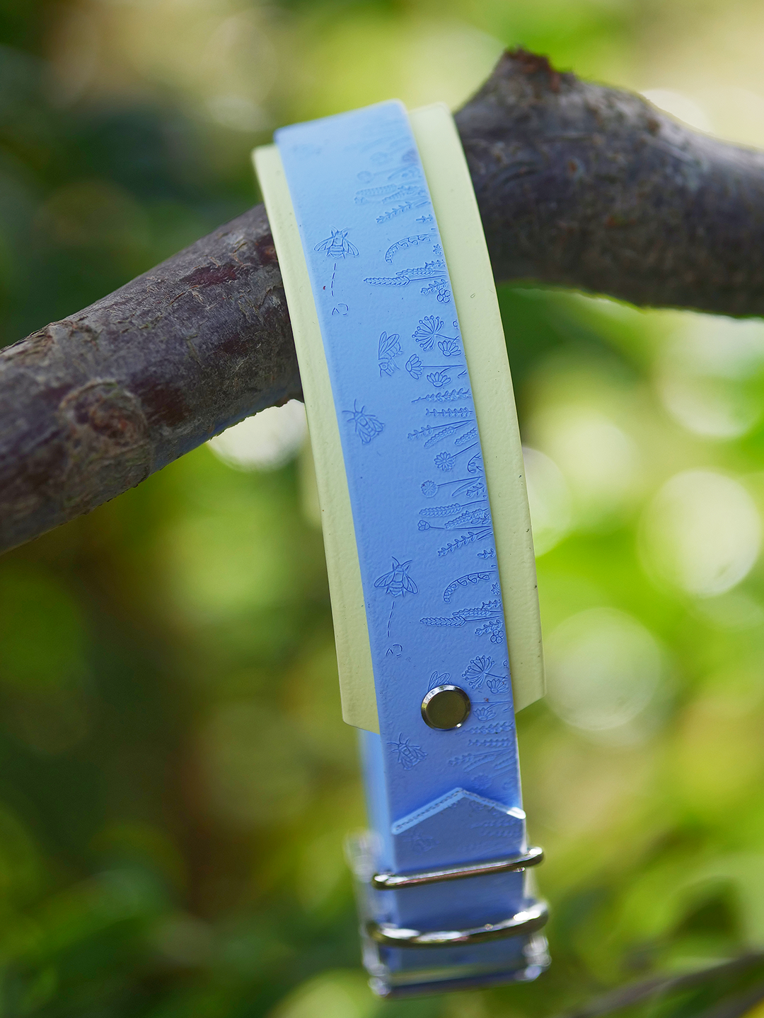 Pastel blue floral dog collar displayed outdoors in natural woodland setting